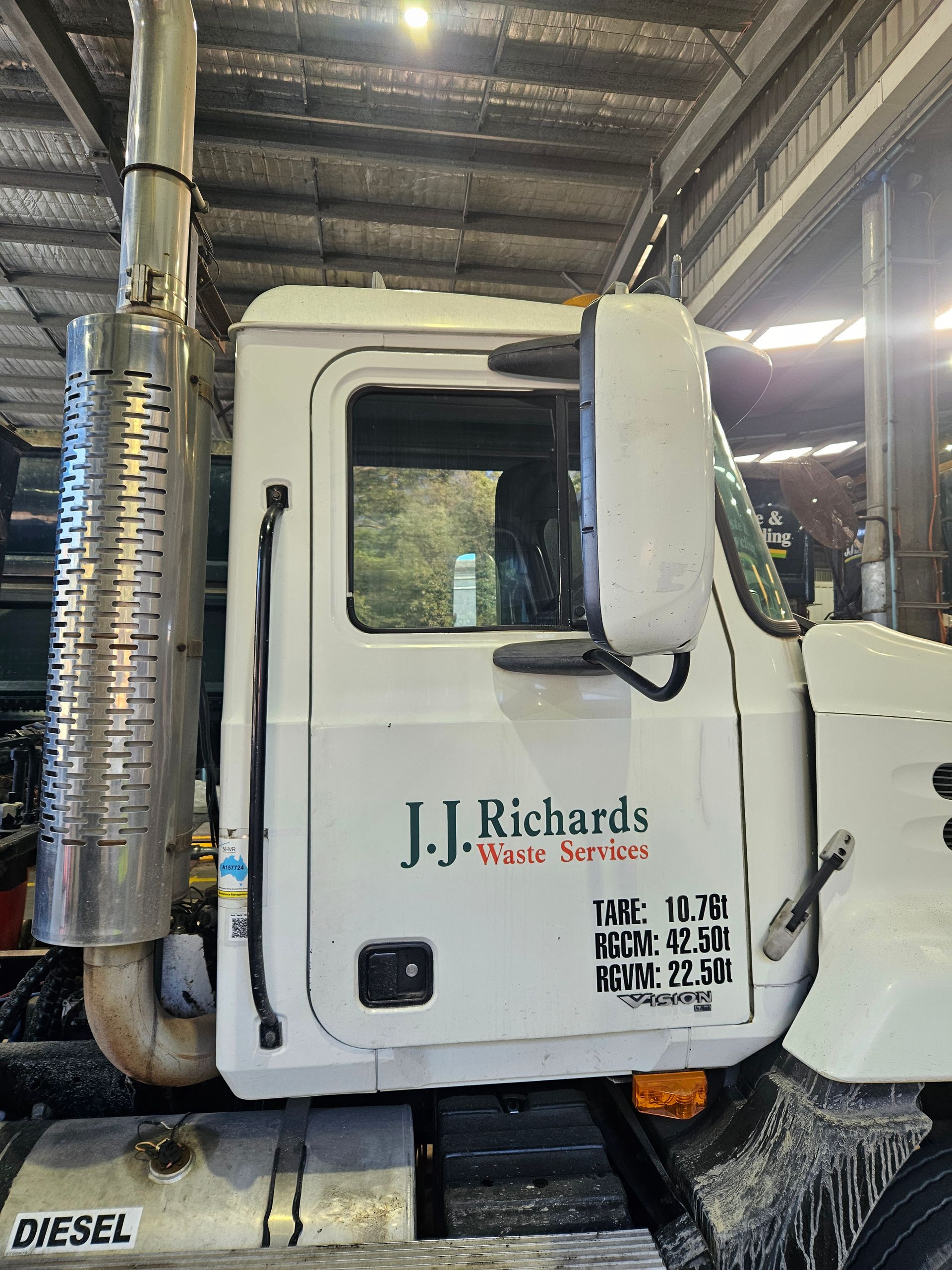White J.J. Richards truck cab with large exhaust pipe. Text on the door reads 