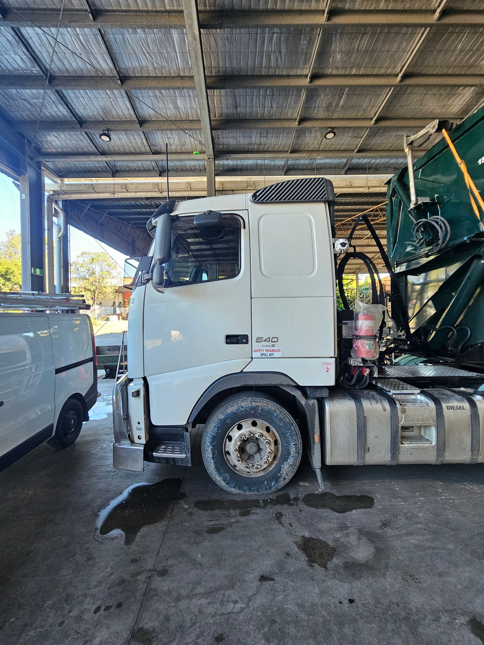 A couple of tractors are parked in a warehouse.