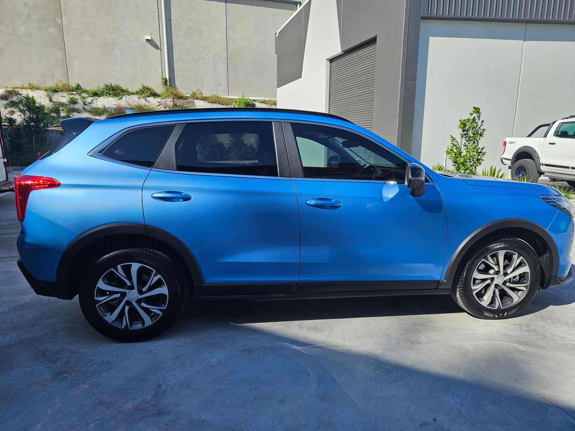 Blue SUV parked outside on a sunny day.