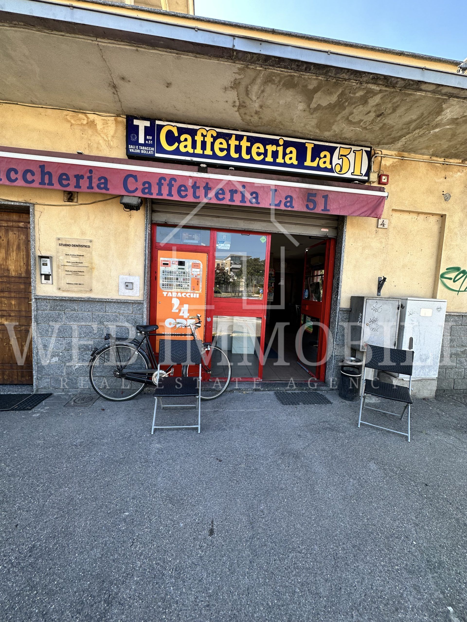 Una vetrina con una tenda rossa, l'insegna 