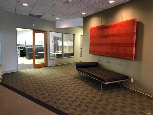 A room with a bench and a large red painting on the wall