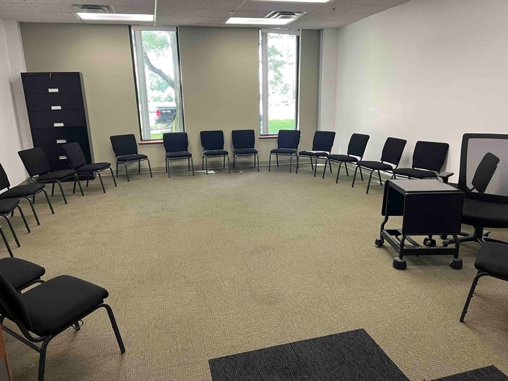 A group of chairs are sitting in a circle in a room.