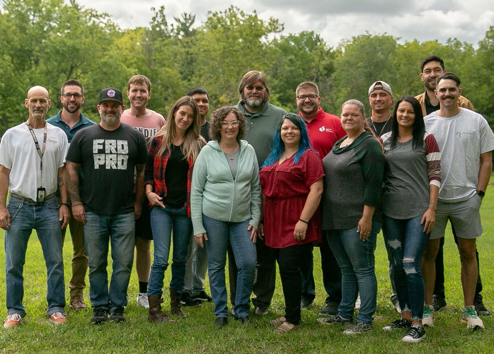 A group of people are posing for a picture in a field.