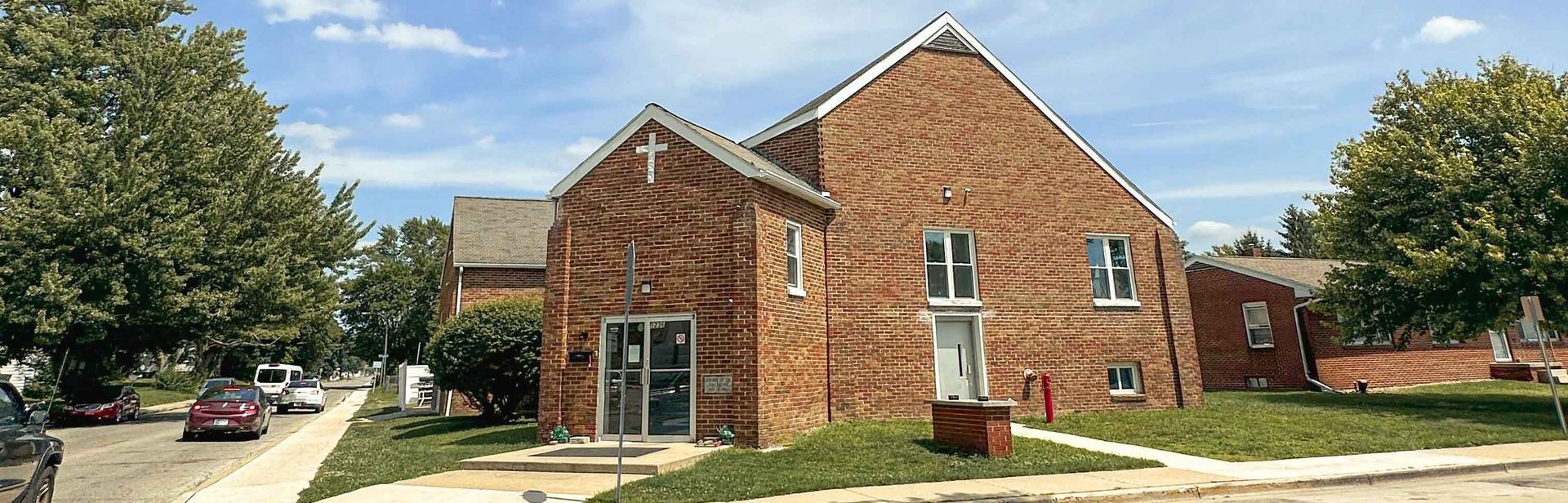 A large brick building with a lot of windows and trees in front of it.