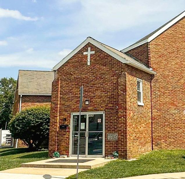 A brick building with a cross on top of it