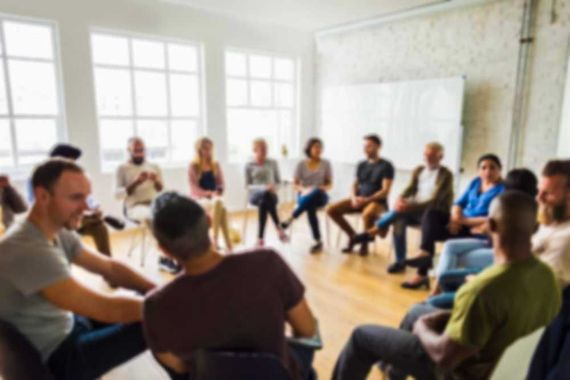 A group of people are sitting in a circle in a room.