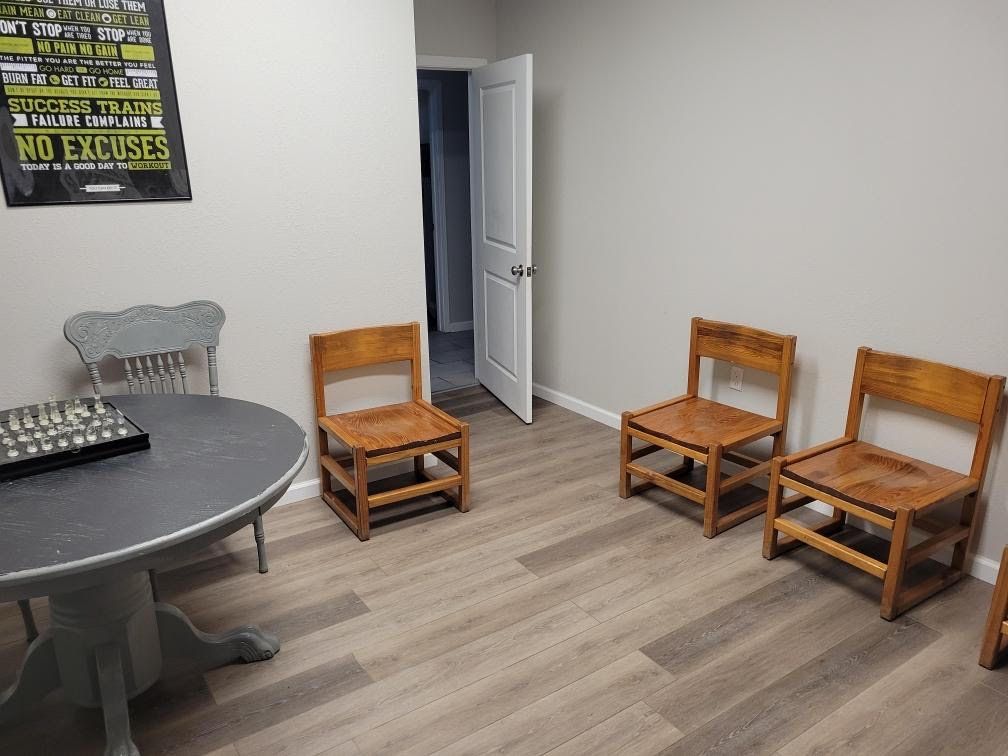 A waiting room with chairs , a table and a chess board.