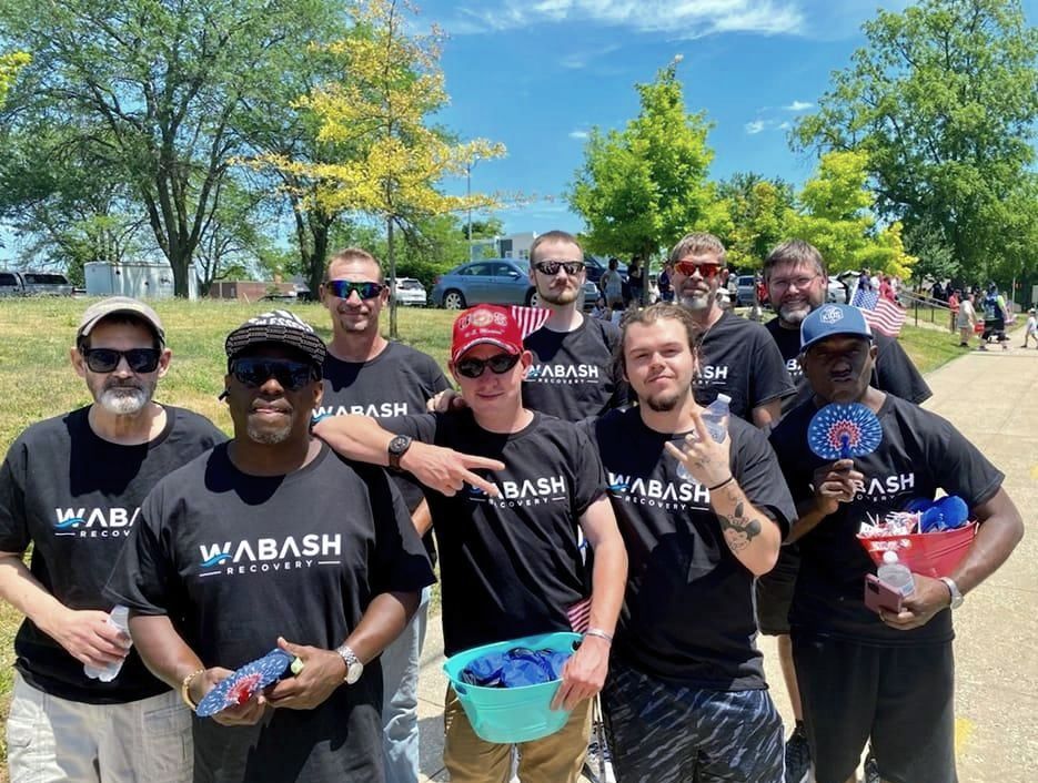 A group of men are posing for a picture in a park.