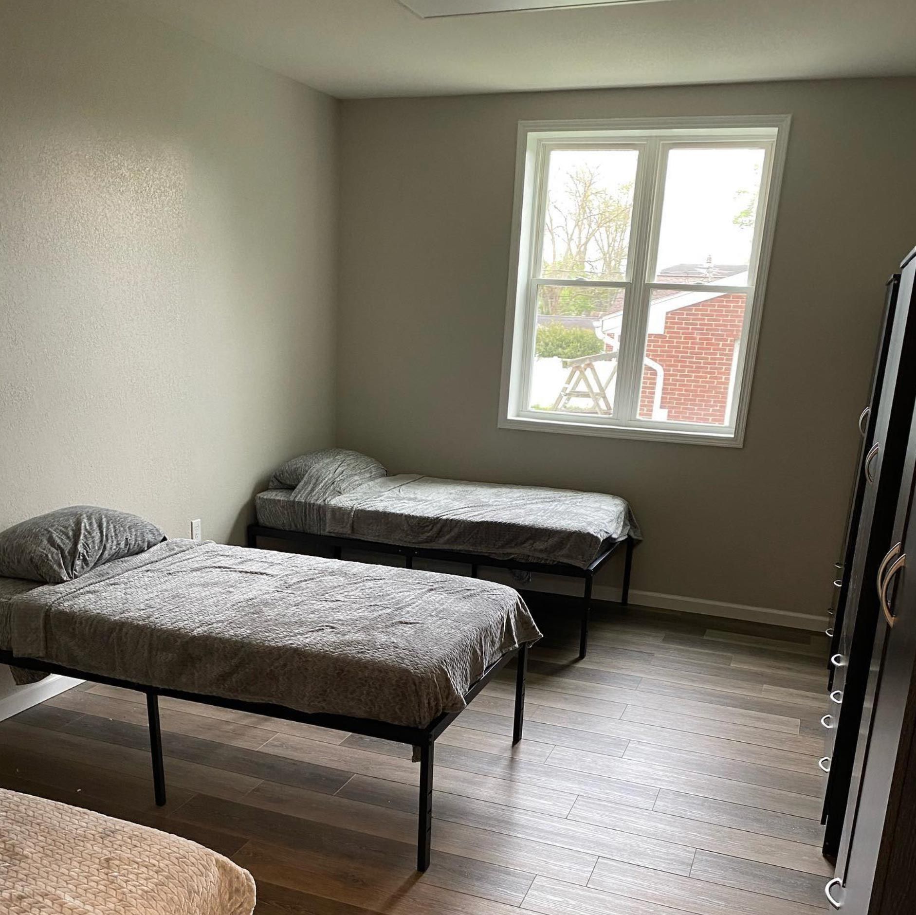 A bedroom with two beds and a window.