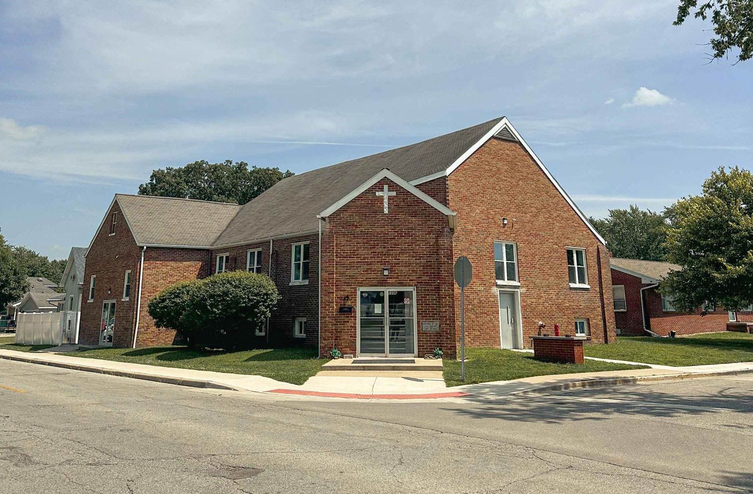 A large brick building with a cross on the top of it.