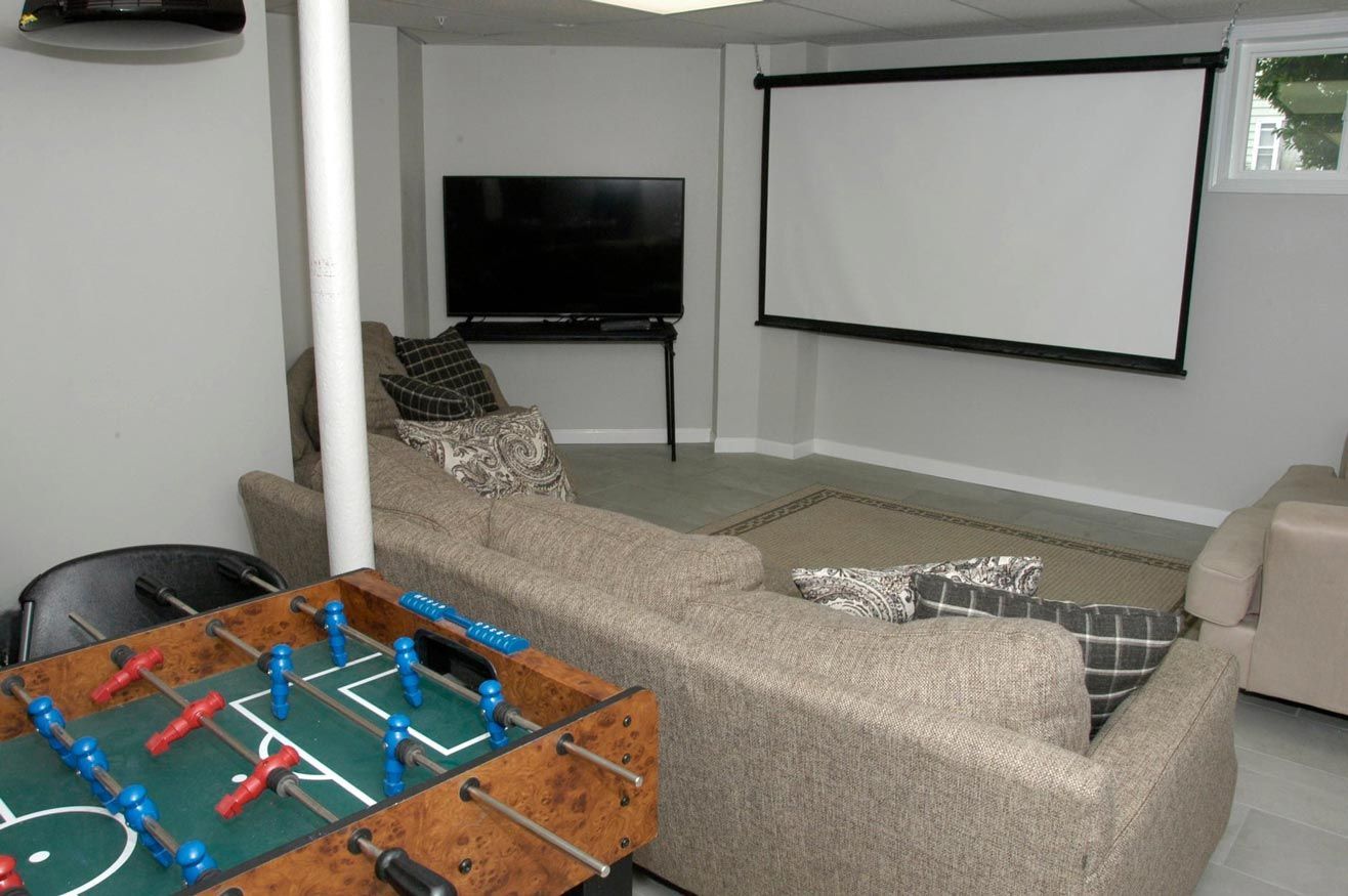 A living room with a projector screen and a foosball table