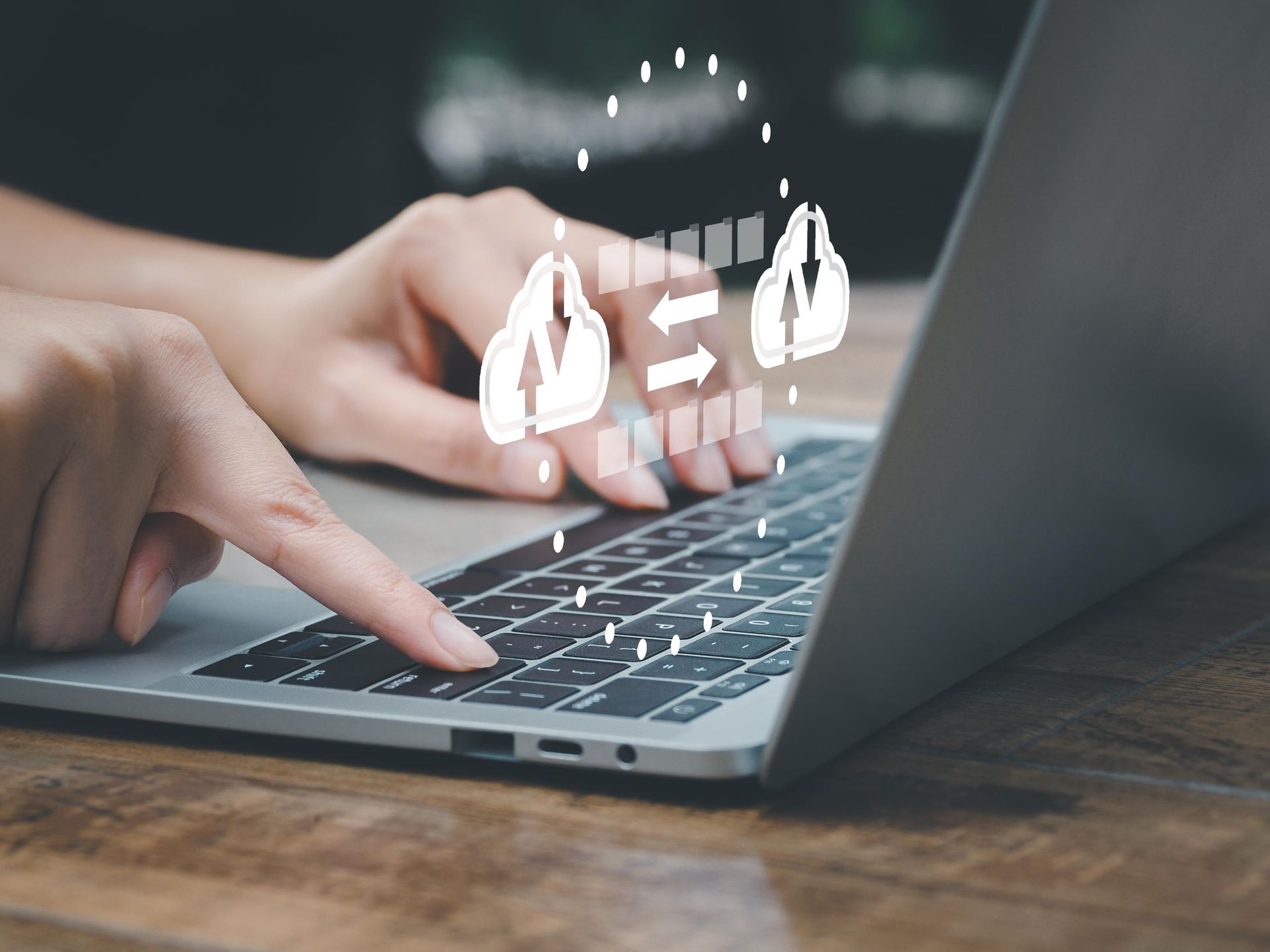 Person typing on a laptop with a digital customer service icon above it.