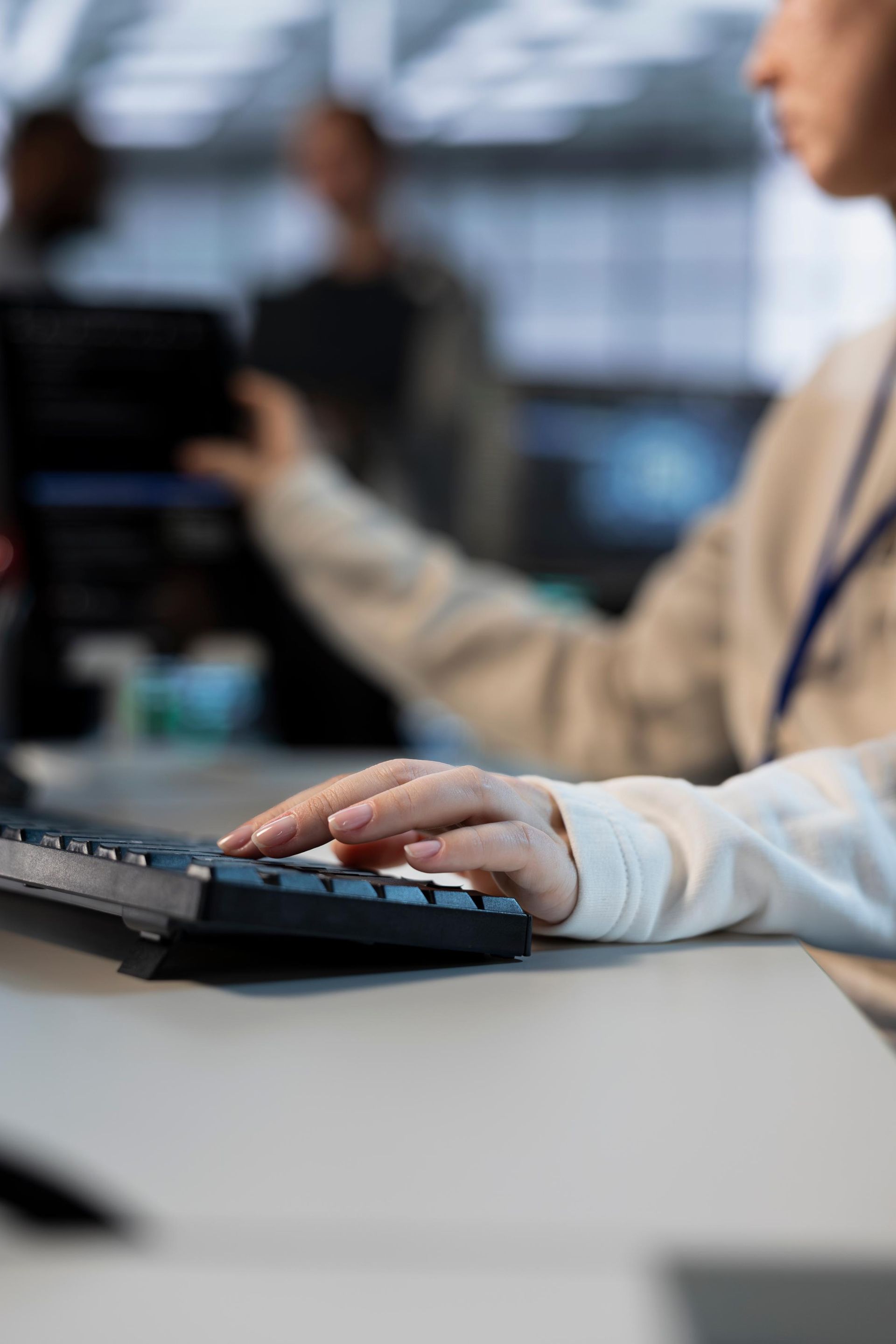 Person's hand typing on a black keyboard. 