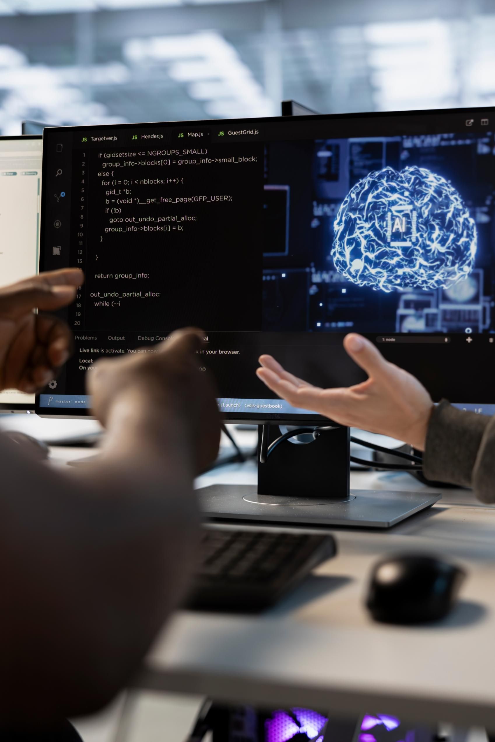 Two people looking at computer monitors with code and a brain graphic.