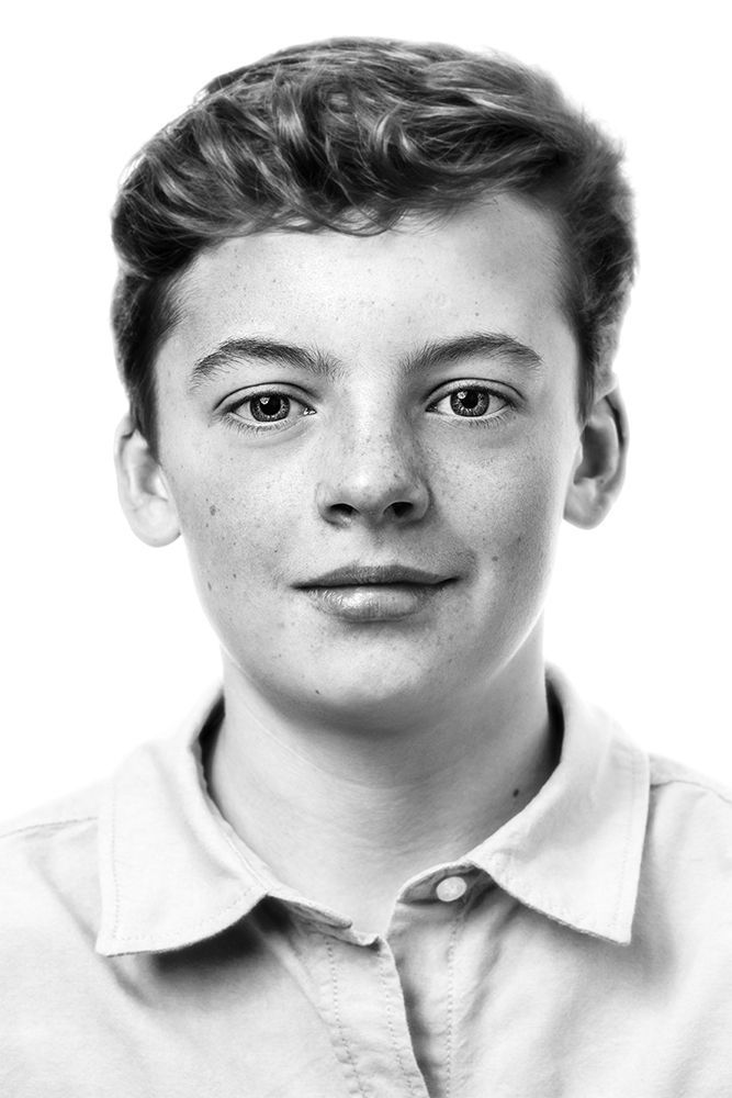 A classical photographic portraiture work, a close up of a young boy in incredible detail, shot in black and white.