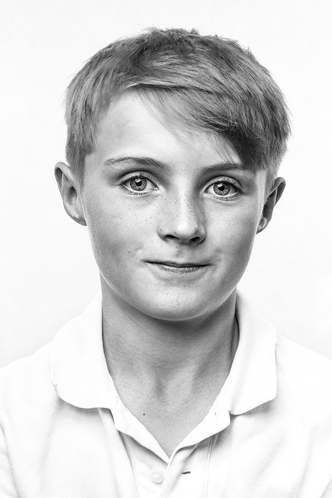 A classical photographic portraiture work, a close up of a young boy in incredible detail, shot in black and white.