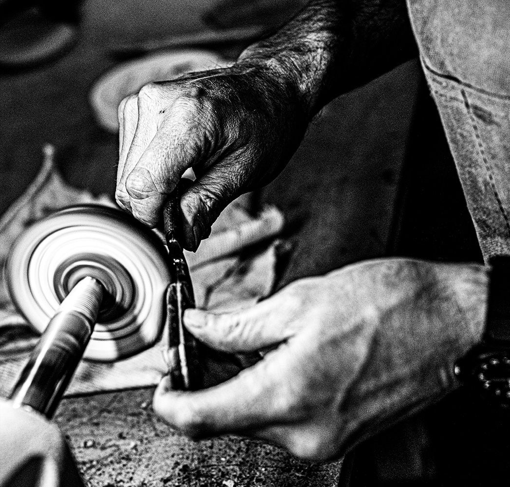 Knife maker fine art portraiture focusing on the equipment used, edited in black and white.