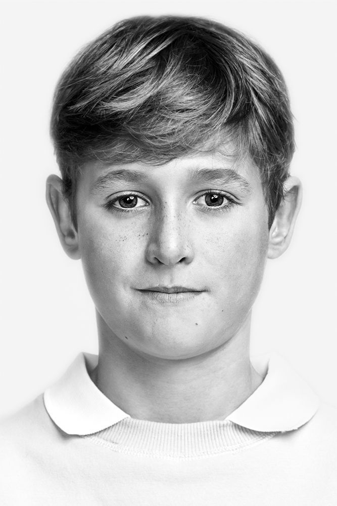 A classical photographic portraiture work, a close up of a young boy in incredible detail, shot in black and white.