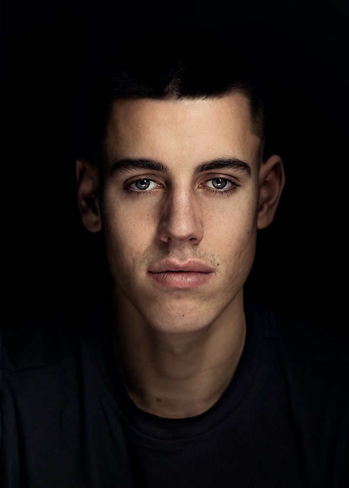 A classical photographic portraiture work, a close up of a young man in incredible detail, with the eyes as a central focus.