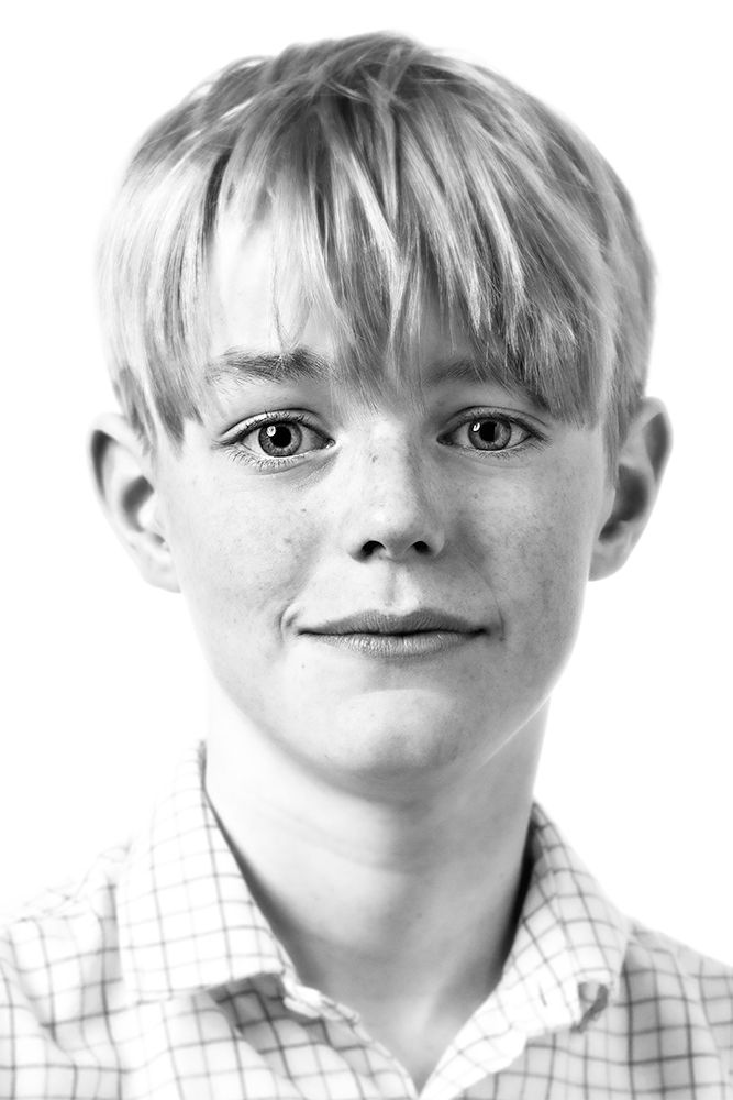 A classical photographic portraiture work, a close up of a young boy in incredible detail, shot in black and white.