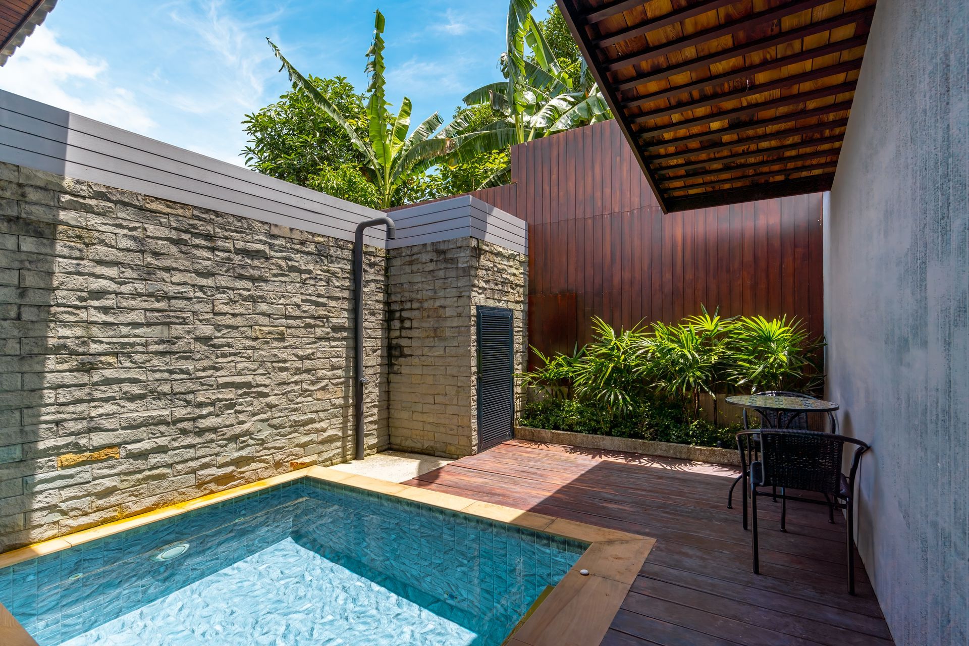 There is a small swimming pool in the backyard of a house.