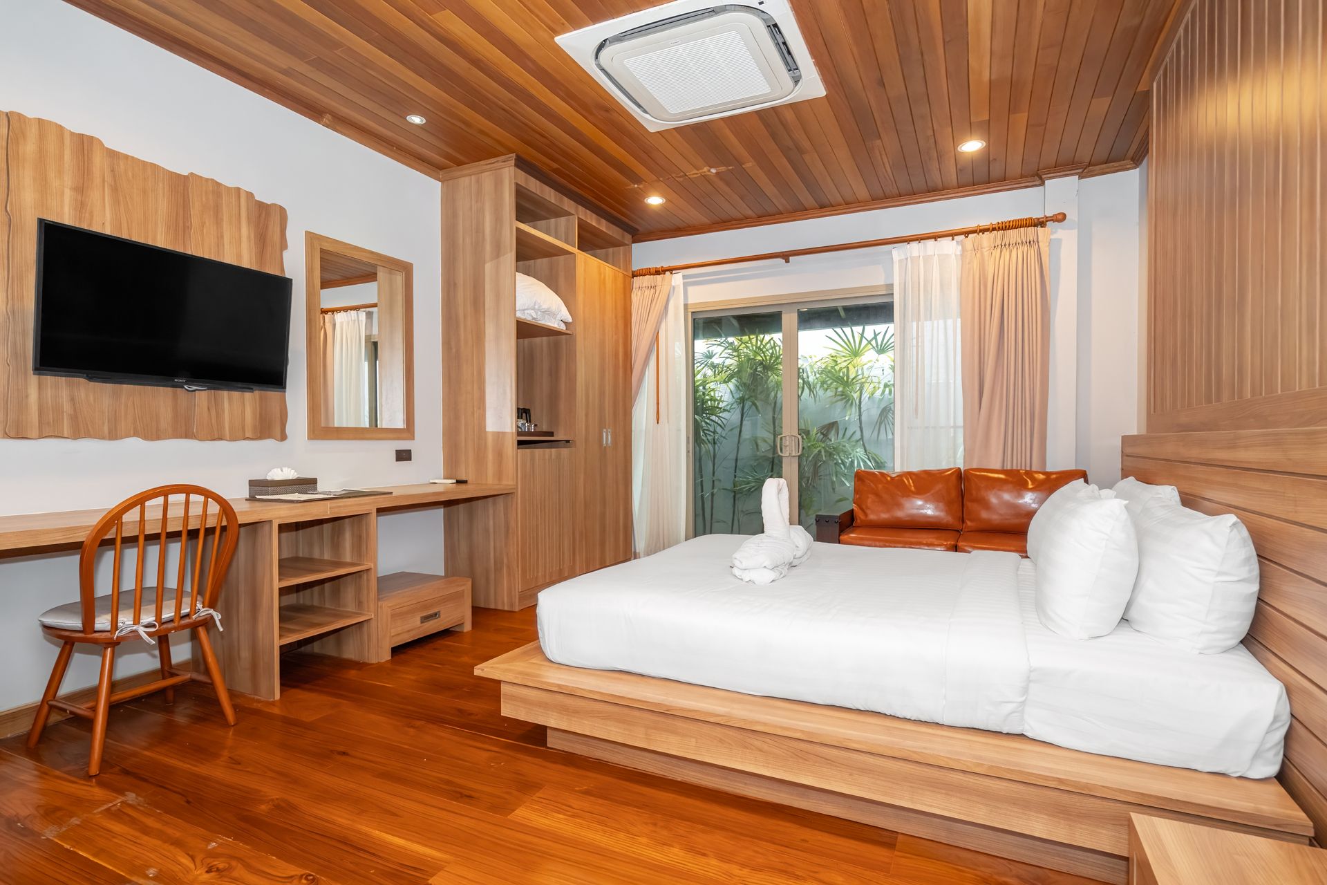 A hotel room with a bed , couch , desk and television.