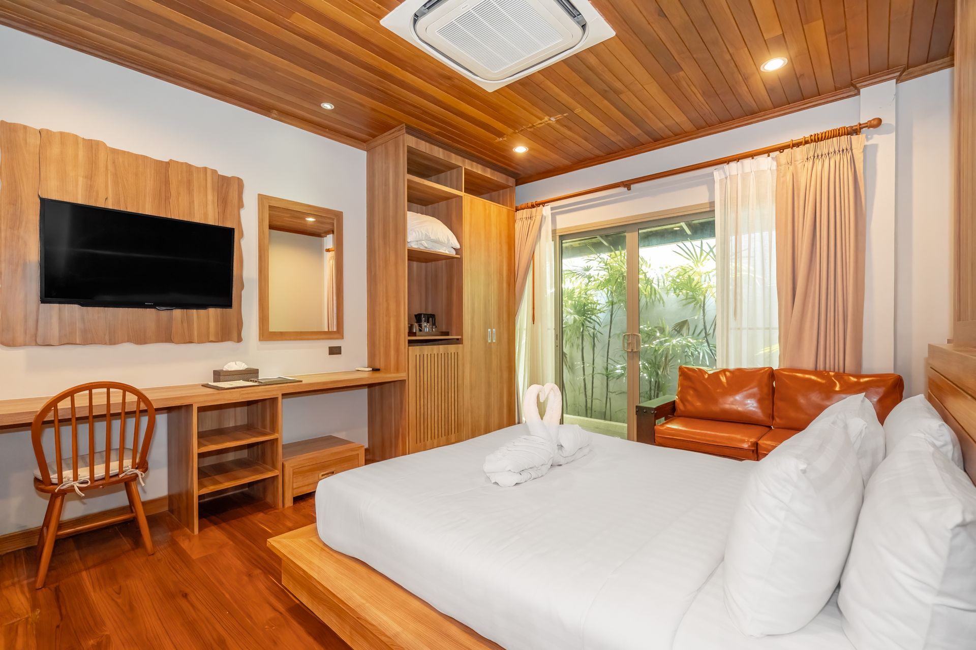 A hotel room with a bed , couch , desk and television.