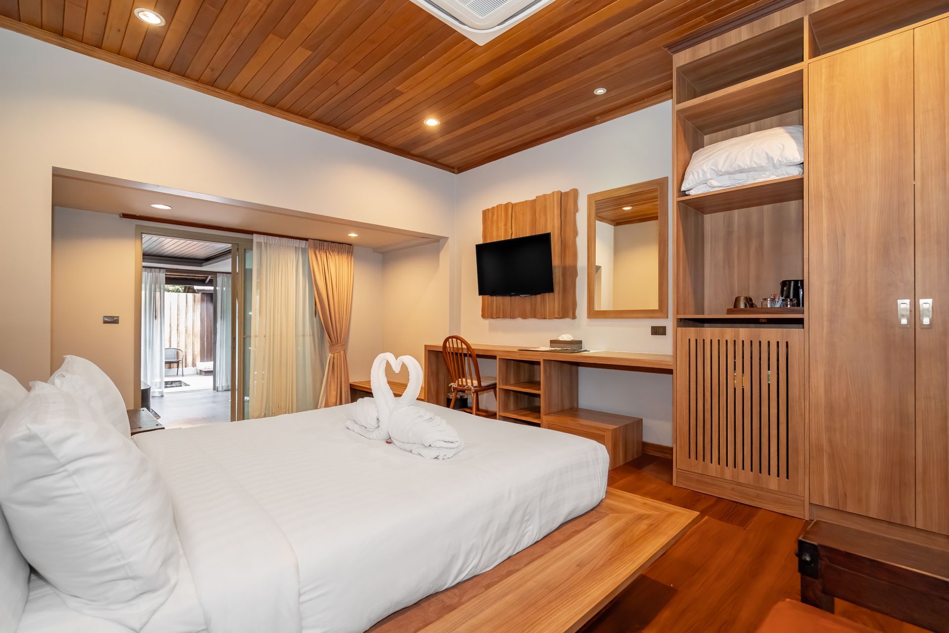 A hotel room with a king size bed and a wooden ceiling.