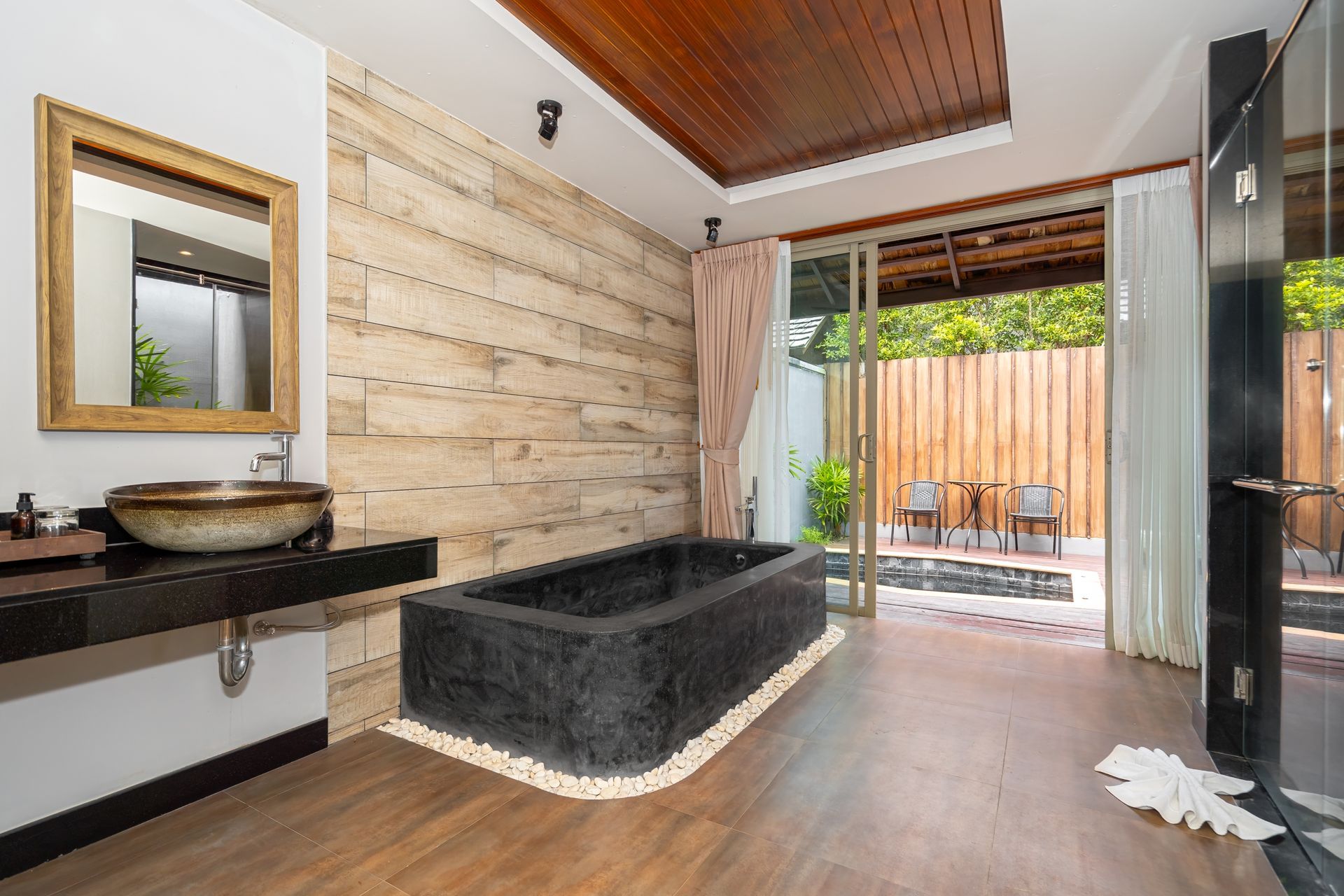 A bathroom with a bathtub , sink and mirror.