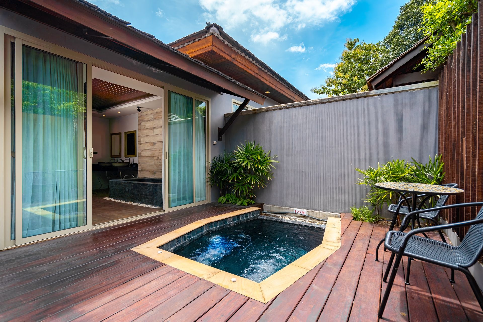 There is a small pool on the deck of a house.