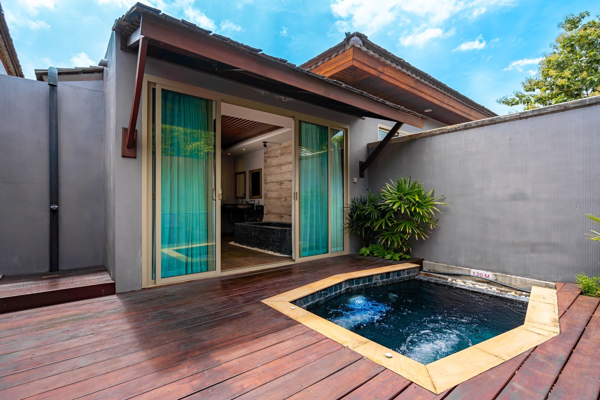 There is a small pool in the backyard of a house.