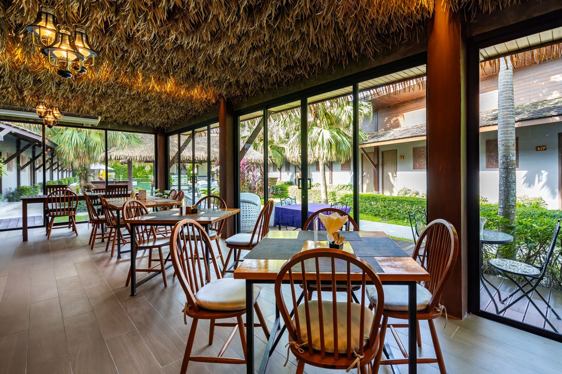 A restaurant with tables and chairs and a lot of windows.