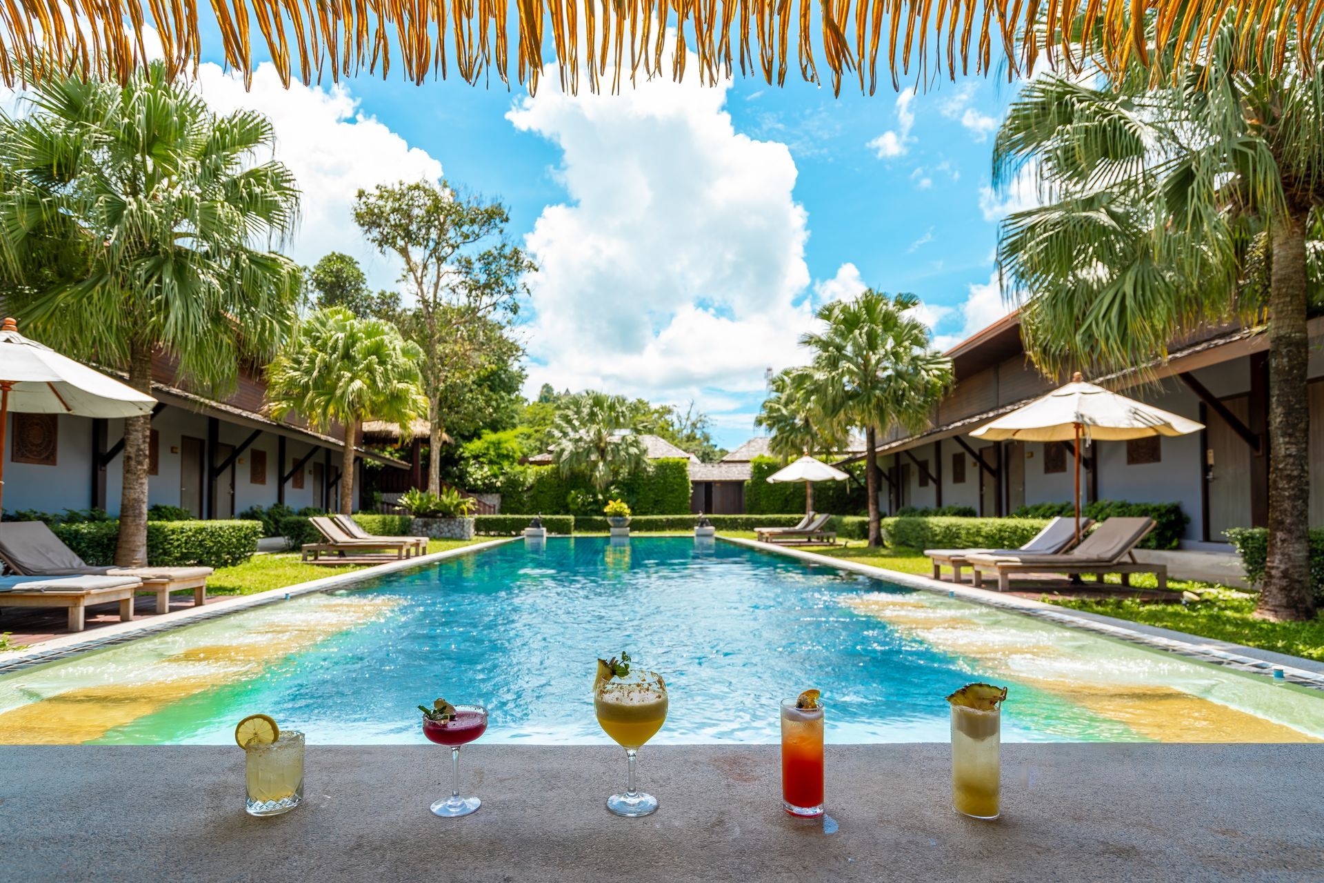 A swimming pool with a bar and drinks in front of it.