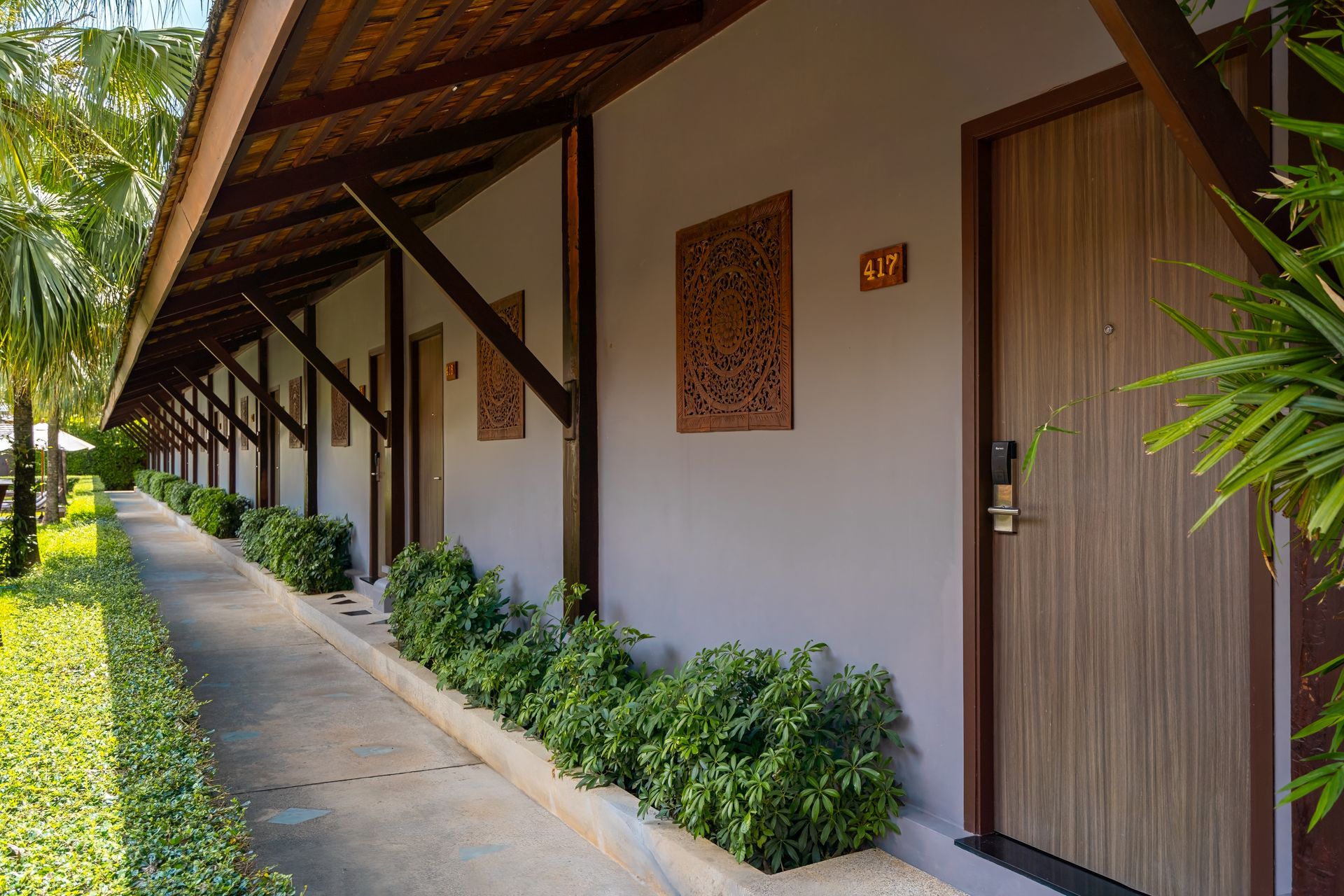 A row of hotel rooms with a walkway leading to them.