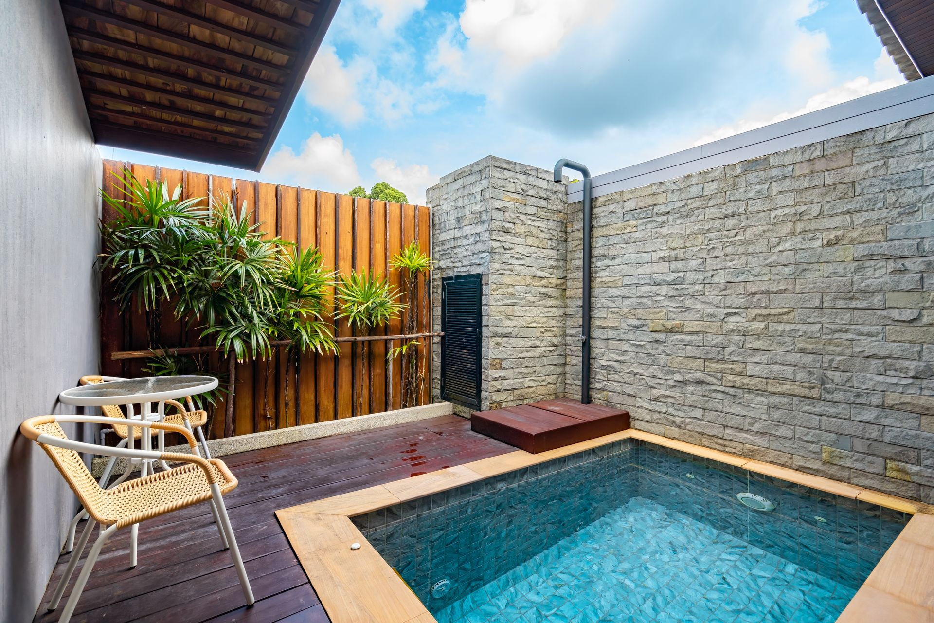 There is a small swimming pool in the backyard of a house.