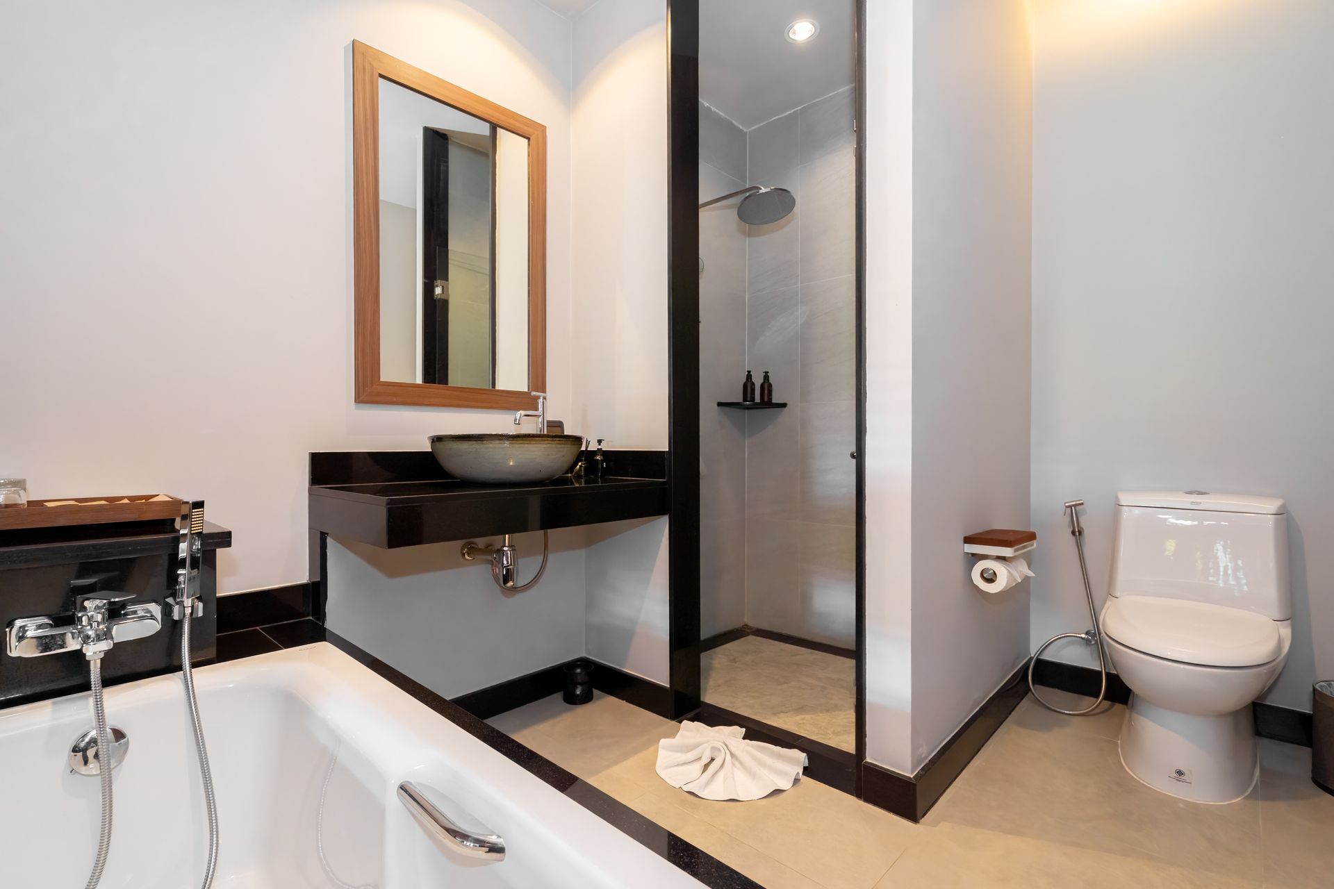 A bathroom with a tub , toilet , sink and mirror.