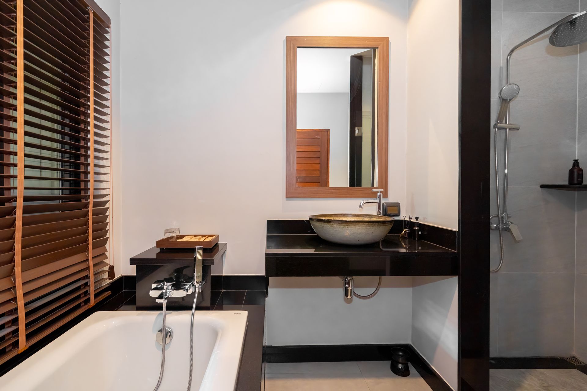 A bathroom with a bathtub , sink , mirror and shower.