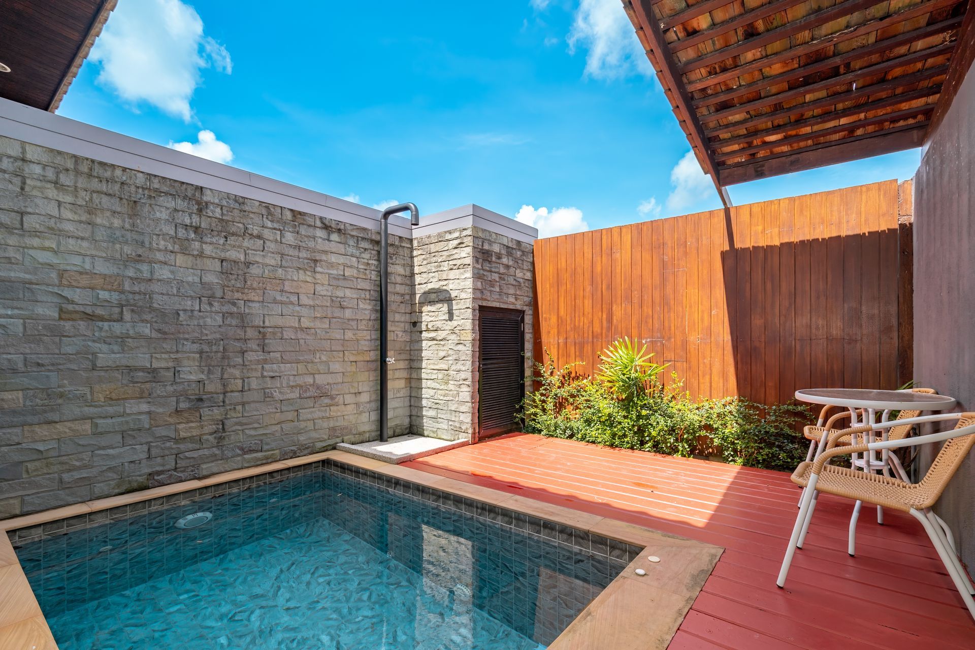 There is a small swimming pool in the backyard of a house.