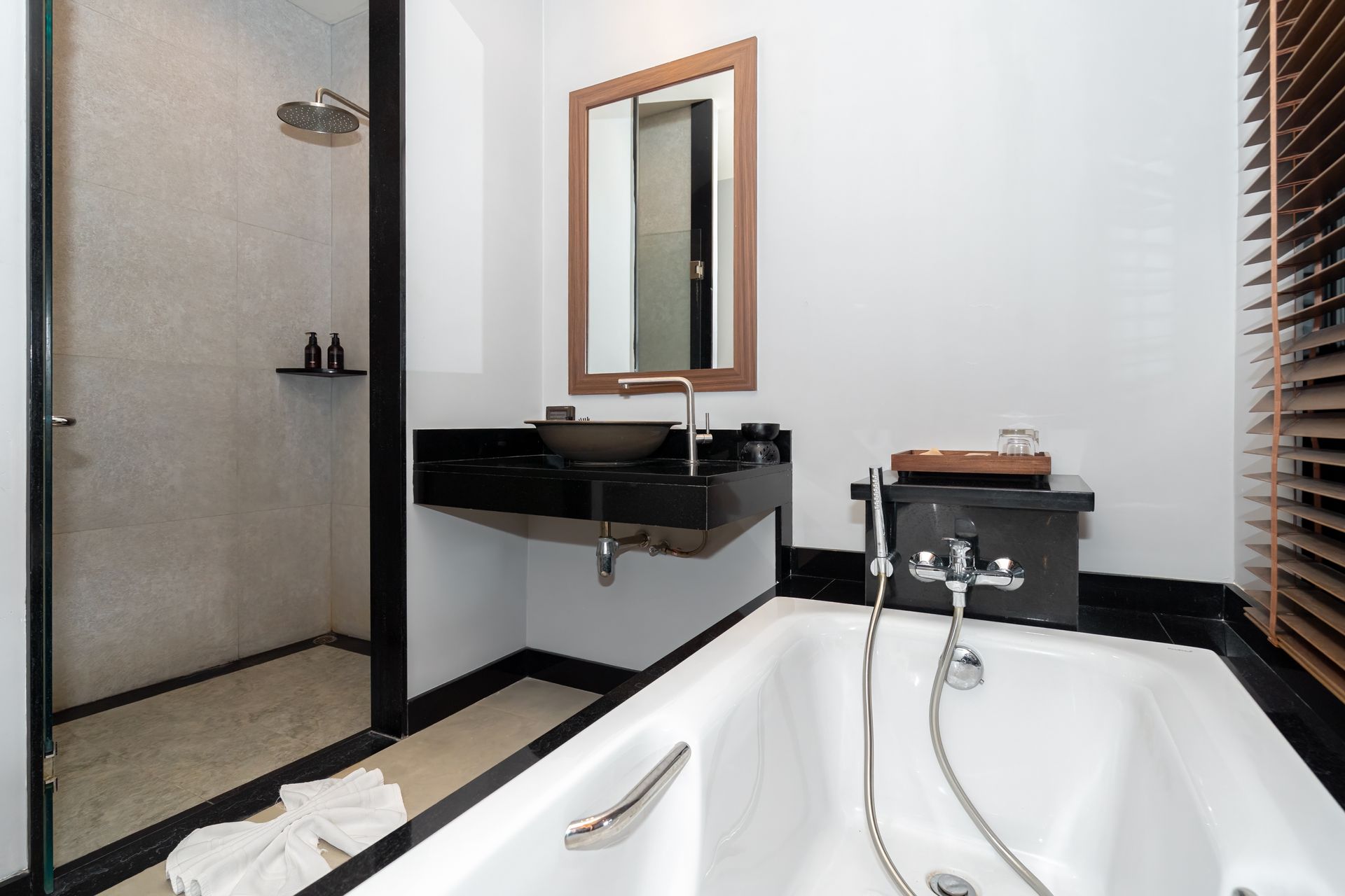 A bathroom with a bathtub , sink , mirror and walk in shower.