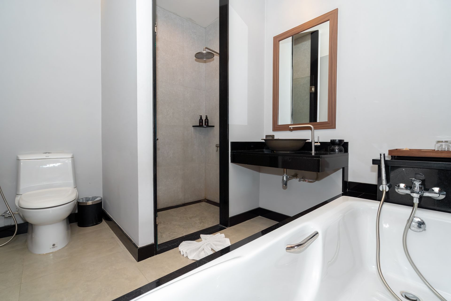 A bathroom with a bathtub , toilet , sink and mirror.