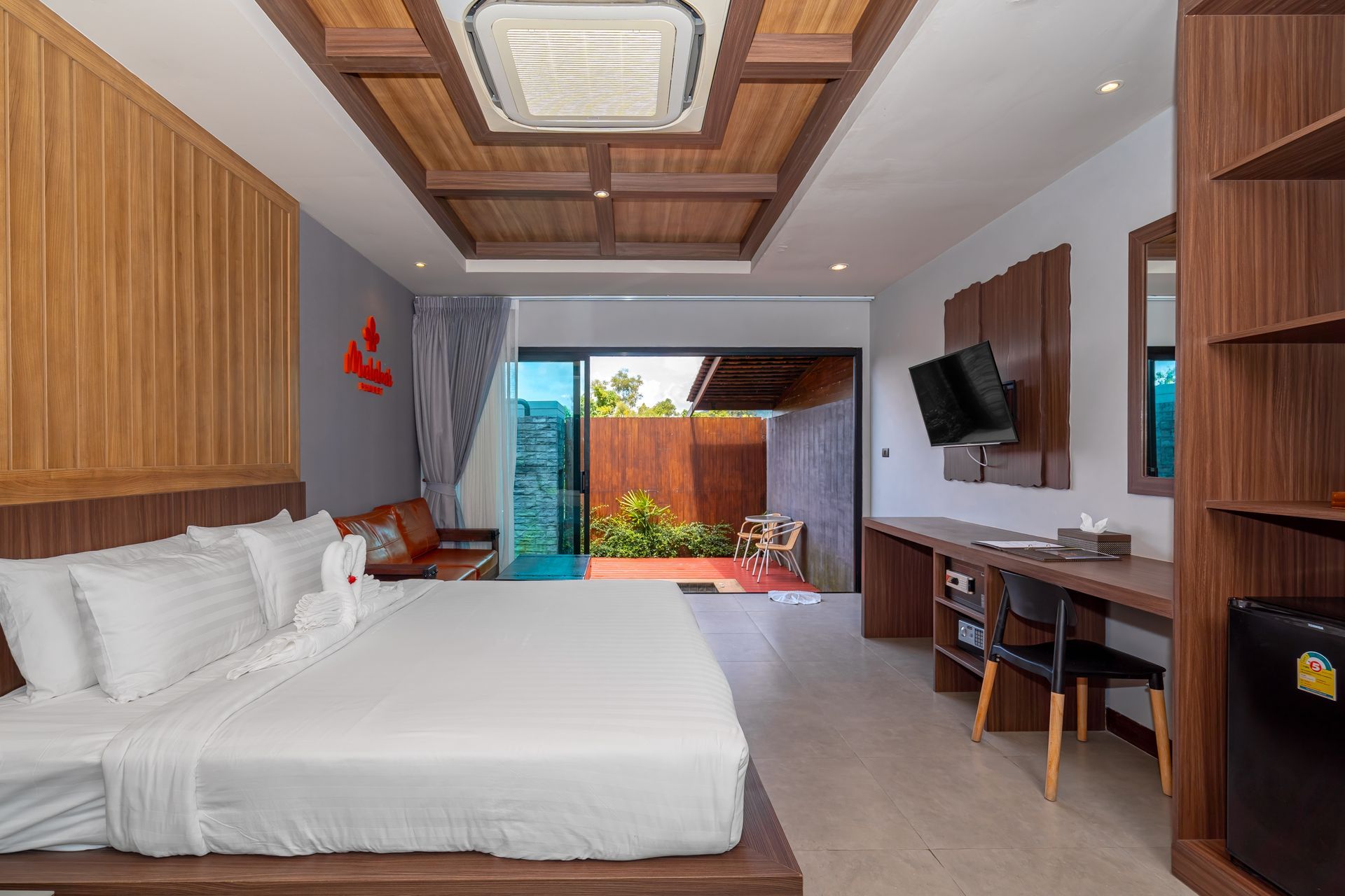 A hotel room with a large bed , desk , chairs and television.