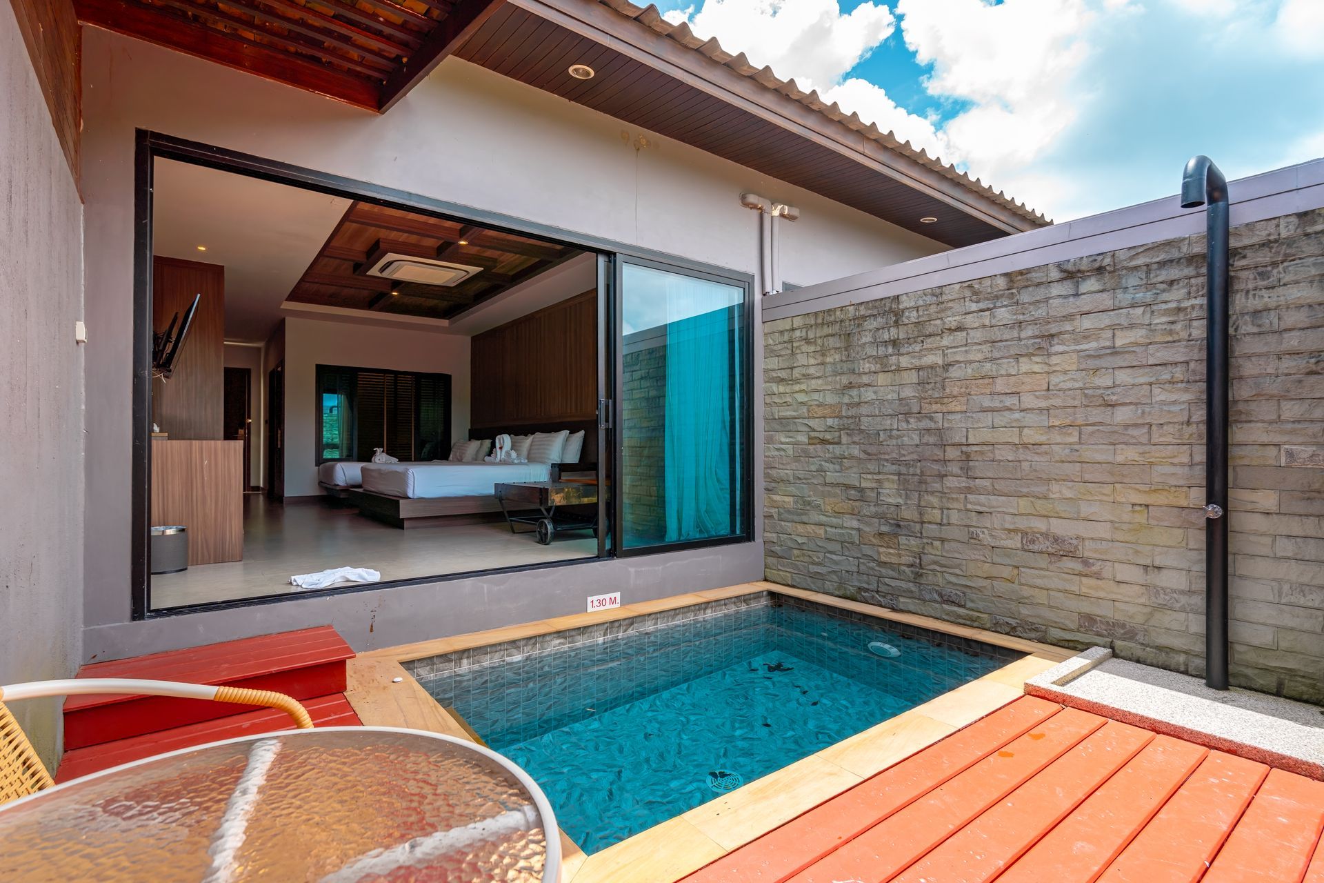 There is a swimming pool in the backyard of a house.