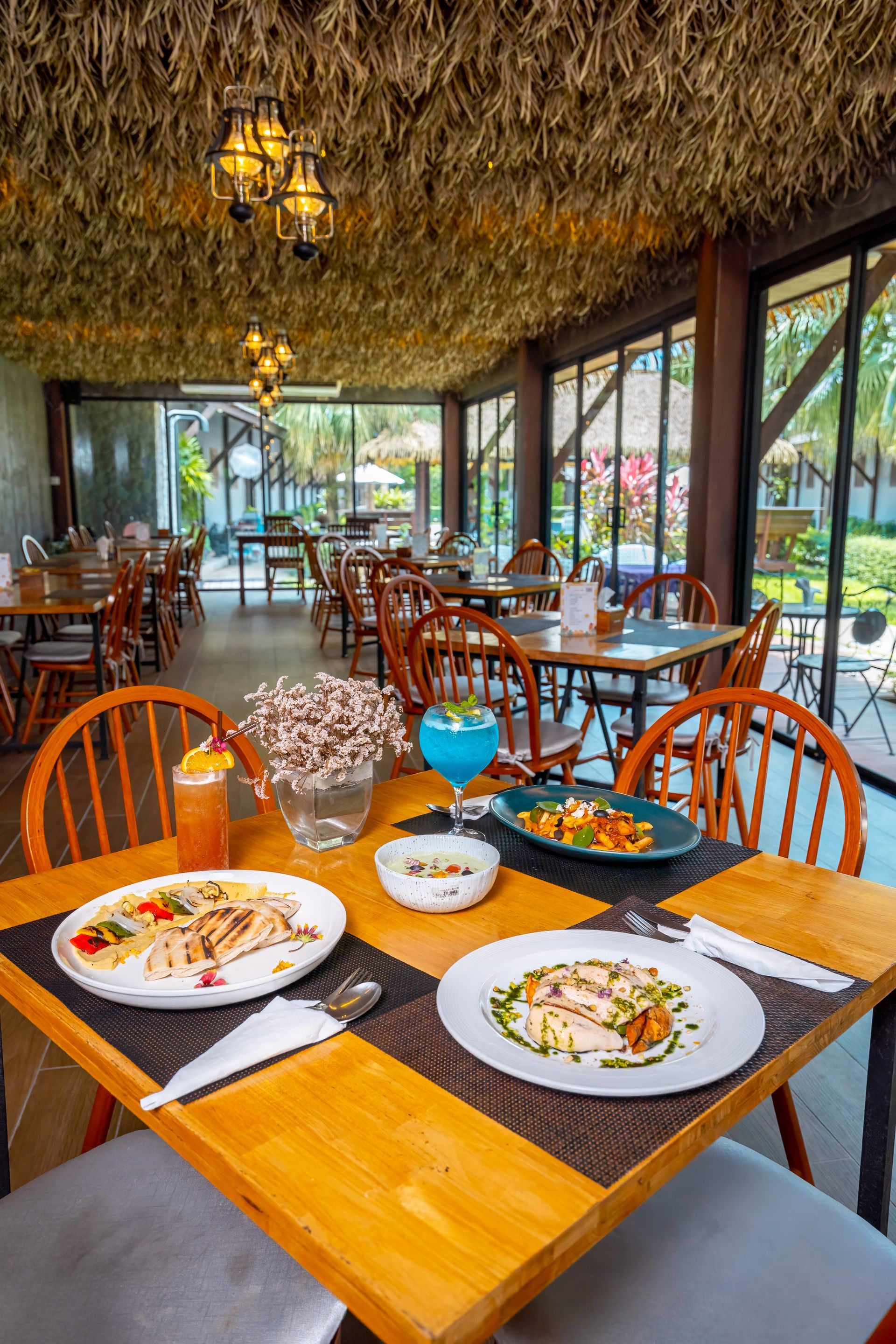 A restaurant with a lot of tables and chairs and plates of food on them.