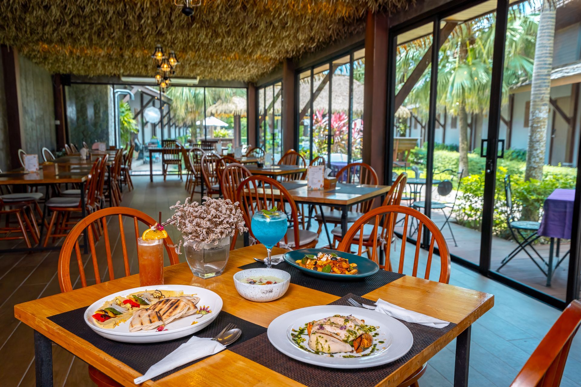 A restaurant with a lot of tables and chairs and plates of food on them.