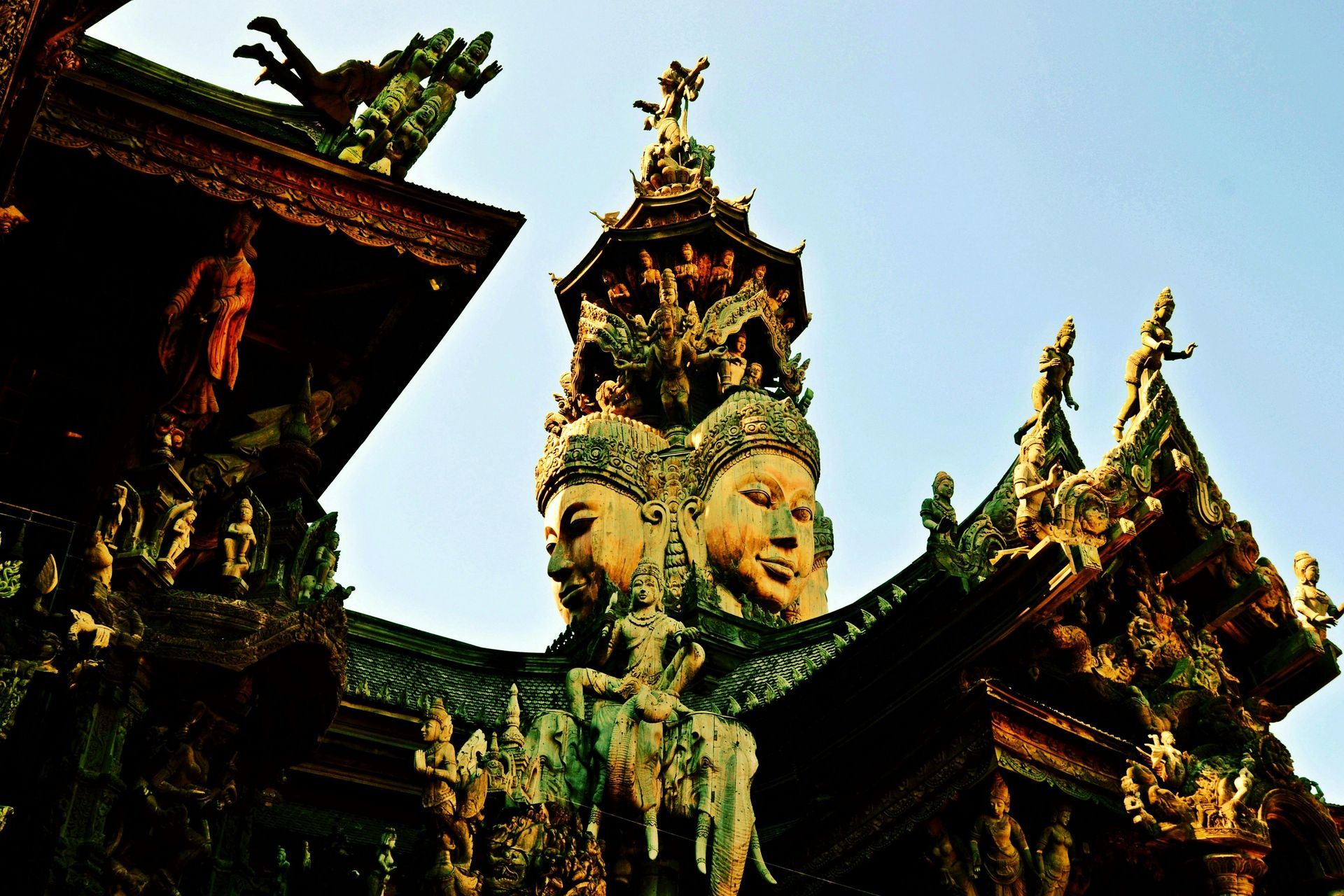 A building with a statue of three buddhas on top of it