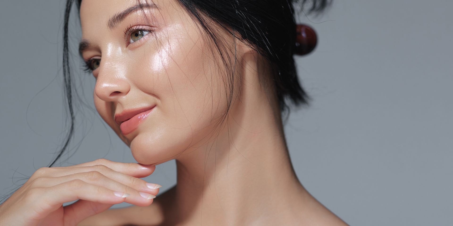 A close up of a woman 's face with her hand on her chin.