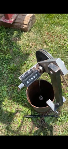 Looking down a dark cylindrical shaft at a camera on a cable.