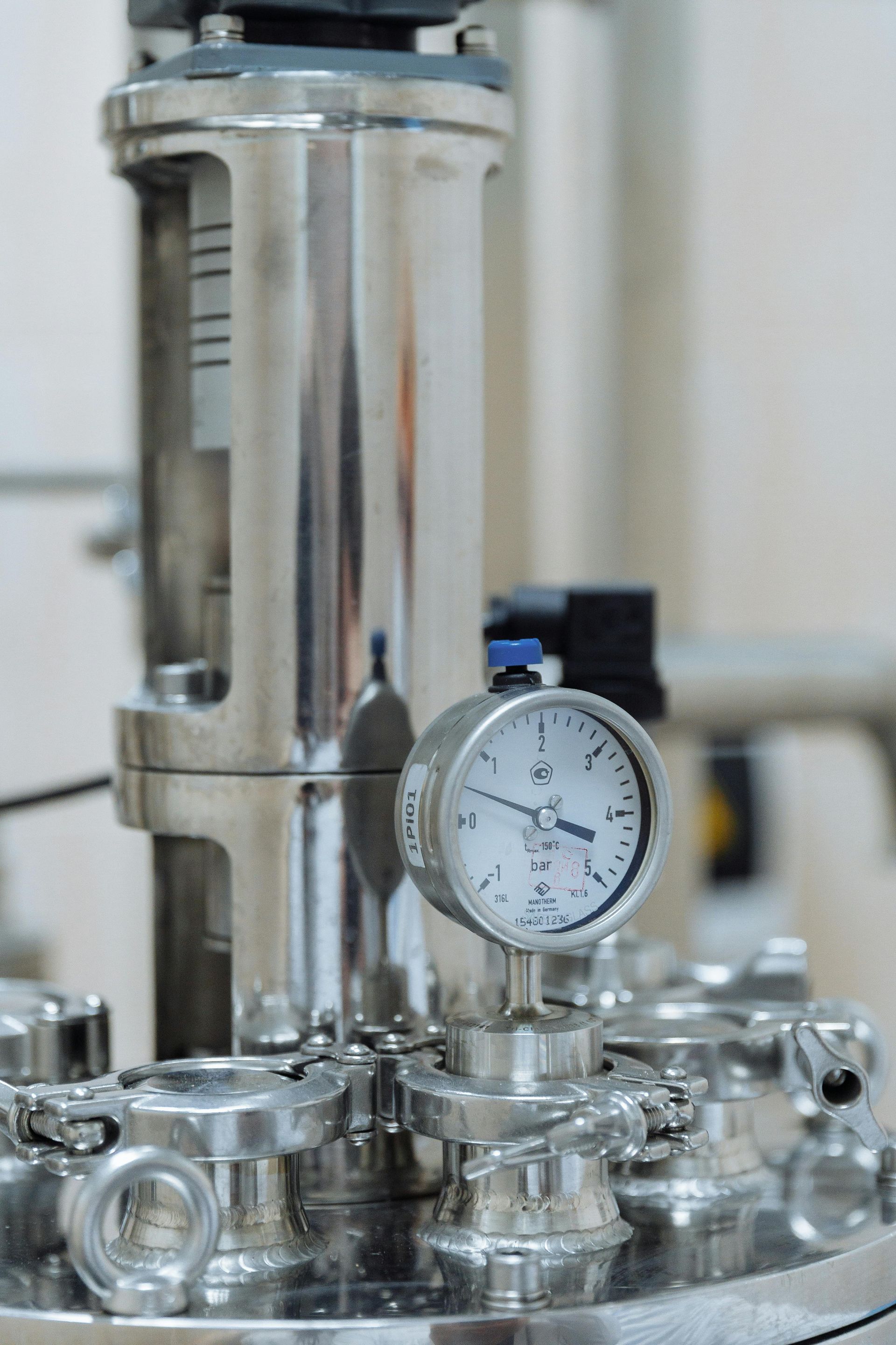 Stainless steel pressure gauge on industrial equipment.