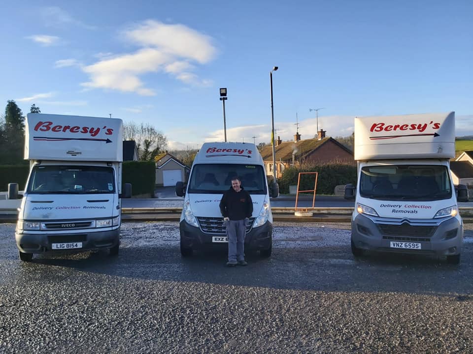 Removals expert stood outside three removal vans