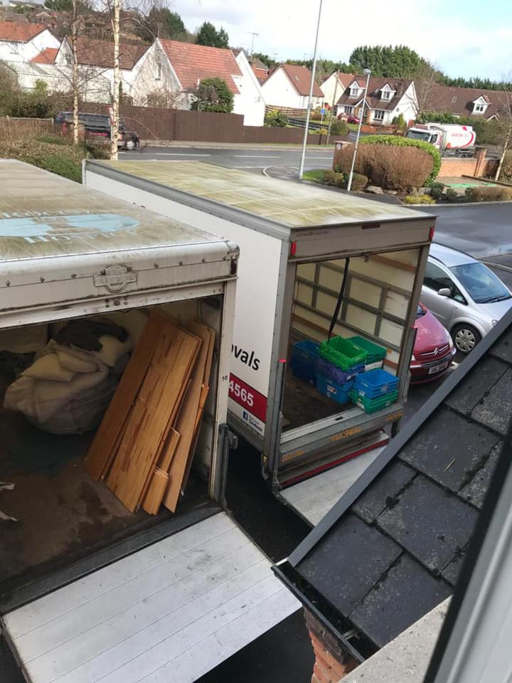 Two removal vans parked next to each with items in the back